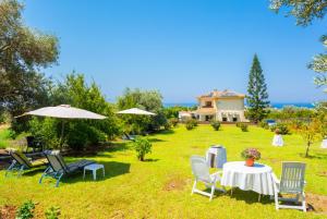 a yard with a table and chairs and a house at Villa Olivetta in Paphos