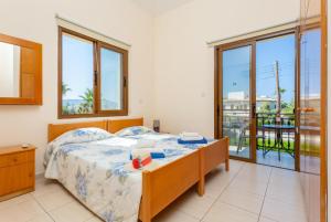 a bedroom with a bed and a balcony at Villa Halima Fostira in Polis Chrysochous
