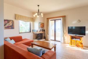 sala de estar con sofá y TV en Villa Selini, en Roussospítion