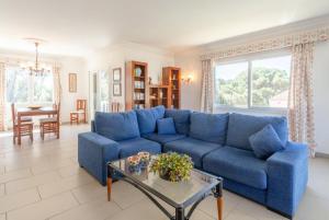 a living room with a blue couch and a table at Villa Luisa in Cala Galdana