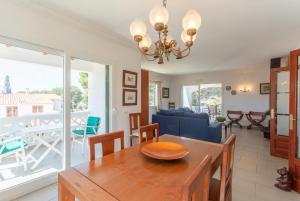 a dining room and living room with a table and chairs at Villa Luisa in Cala Galdana