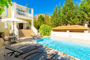 een villa met een zwembad en een huis bij Villa Ismini in Kateliós
