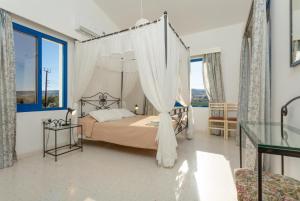 a bedroom with a canopy bed and a window at Villa Charoula Ena in Polis Chrysochous