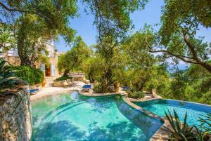 a swimming pool in a yard with trees at The Olive Press - Agni Bay in Agní