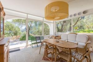 a living room with a table and chairs and windows at The Olive Press - Agni Bay in Agní