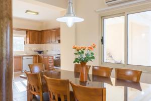a kitchen with a table and chairs and a vase of flowers at Villa Clementina in Kato Yialia