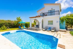 a villa with a swimming pool in front of a house at Sun Beach Villa in Polis Chrysochous