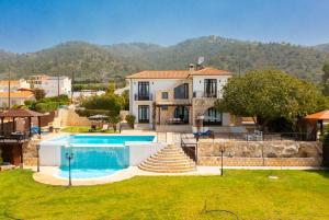 a villa with a swimming pool and a house at Villa Minoas in Argaka