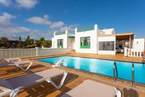 a swimming pool in front of a house at Villa Sol Y Mar in Yaiza
