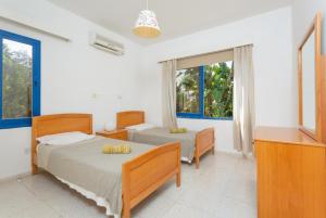 a bedroom with two beds and a window at Villa Charoula Tria in Paphos City +37 photos
