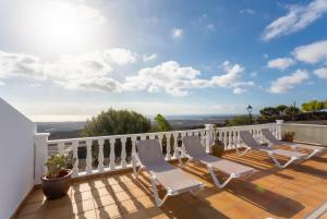 eine Terrasse mit weißen Stühlen auf dem Balkon in der Unterkunft Villa Sol Y Mar in Yaiza