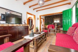 a living room with wooden furniture and a flat screen tv at Villa Sol Y Mar in Yaiza