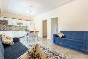 a living room with a blue couch and a kitchen at Villa Duman 1 in Dalyan