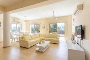 a living room with a couch and a table at Villa Rose in Paphos City