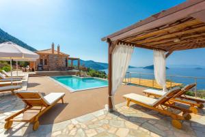 uma villa com vista para o oceano e uma piscina em Villa Diona em Panormos