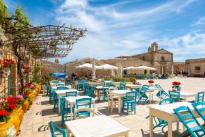 a row of tables and chairs in a courtyard at Villa Palazzola in Scicli
