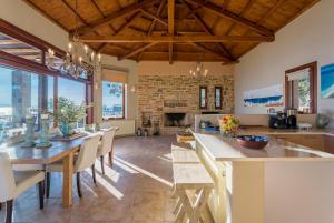 uma cozinha e sala de jantar com mesa e cadeiras em Villa Diona em Panormos