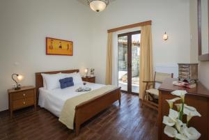 1 dormitorio con cama, escritorio y ventana en Villa Ilia, en Roussospítion
