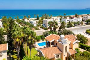 arial view of a villa with palm trees and the ocean at Villa Halima Stefanos in Polis Chrysochous