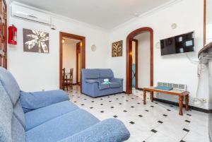 sala de estar con sofá azul y mesa en Villa Emilio en Cala'n Porter