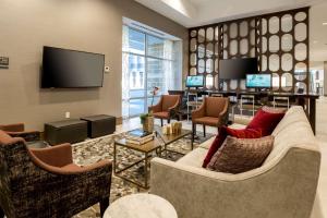 a living room with furniture and a flat screen tv at DoubleTree by Hilton Evansville in Evansville