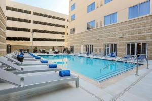 a pool in the courtyard of a building with chairs at DoubleTree by Hilton Evansville in Evansville