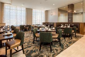 uma sala de jantar com mesas e cadeiras num restaurante em DoubleTree by Hilton Evansville em Evansville