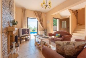 ein Wohnzimmer mit einem Sofa und einem TV in der Unterkunft Villa Marina in Svoronata