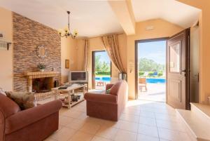 a living room with two chairs and a fireplace at Villa Marina in Svoronata