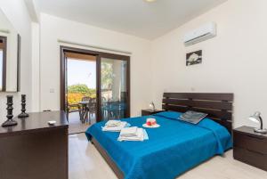 Un dormitorio con una cama con una colcha azul. en Villa Fortuna, en Polis Chrysochous 44 fotos más