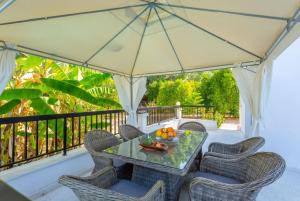 a table and chairs on a porch with a umbrella at Villa Charoula Thio in Polis Chrysochous