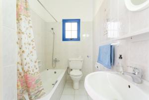 a white bathroom with a tub and a toilet and a sink at Villa Charoula Thio in Polis Chrysochous +47 photos