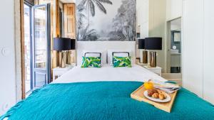 a bedroom with a bed with a tray of food on it at Downtown PortoEdition in Porto