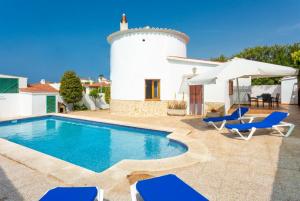 a villa with a swimming pool and a house at Villa Maria in Cala en Porter