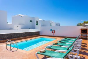 a pool with lounge chairs and a swimming pool at Villa Costa Papagayo 5 in Playa Blanca