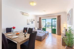 a dining room and living room with a table and a couch at Villa Costa Papagayo 5 in Playa Blanca