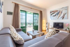 a living room with a couch and a television at Villa Costa Papagayo 5 in Playa Blanca