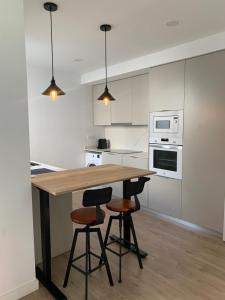 a kitchen with a wooden table and three bar stools at DeCASTA in Chulilla