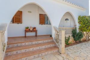a staircase in a white house with two arches at Villa Maria Large Private Pool AC WiFi in Cala en Porter