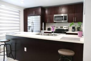 a kitchen with a sink and a stove top oven at Insta Worthy Modern Bungalow in Homestead