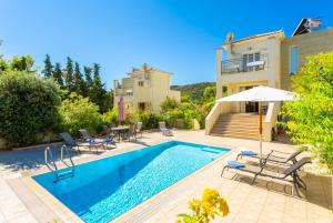een villa met een zwembad en een huis bij Villa Fedra in Póros