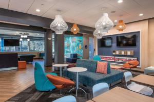 a lobby with tables and chairs and a waiting room at Tru by Hilton Fayetteville I-95 in Fayetteville