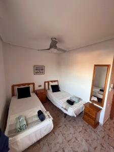 1 dormitorio con 2 camas y espejo en Casa de Don Simón, en Cabo Roig