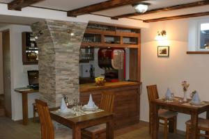 a dining room with two tables and a stone pillar at B&B Millenium House in Plitvička Jezera