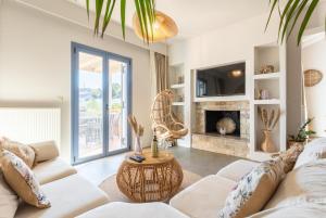 a living room with a white couch and a fireplace at Villa Canova in Mesovoúnia