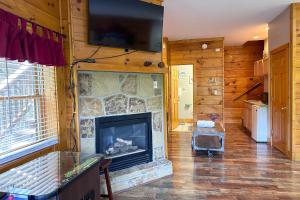 a living room with a fireplace and a flat screen tv at Reindeer Hideaway in Pigeon Forge