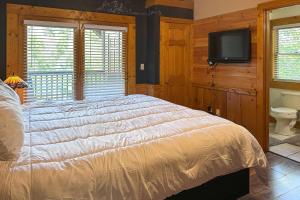 a bedroom with a bed and a tv on a wall at Reindeer Hideaway in Pigeon Forge