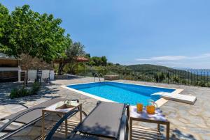 une villa avec une piscine, une table et des chaises dans l'établissement Oak Tree Cottage, à Pefkias