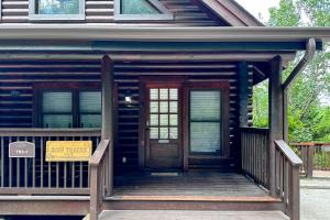 a front door of a log cabin with a sign on it at Reindeer Hideaway in Pigeon Forge