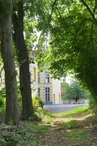 ein großes weißes Haus mit Bäumen davor in der Unterkunft Château de Bellignies 